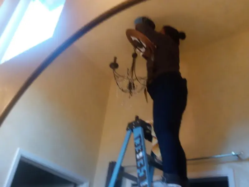 Electrician installing a chandelier in a Orwigsburg residence
